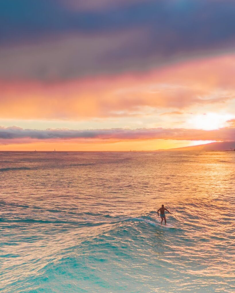 person surfing on sea during sunset