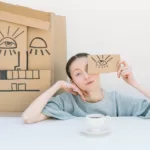 woman holding a cardboard box with a drawing