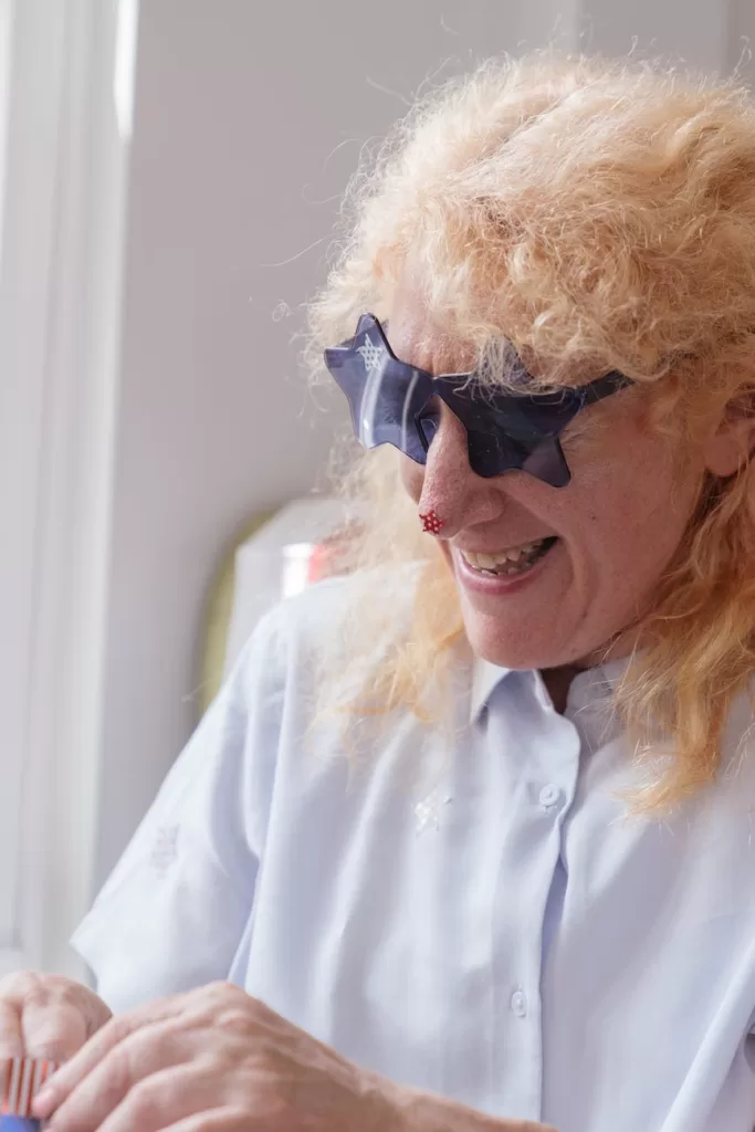 elderly person putting on star shaped sunglasses