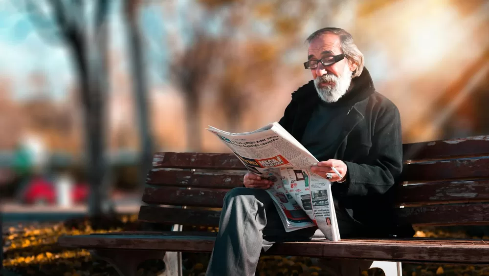 photo of man reading newspaper